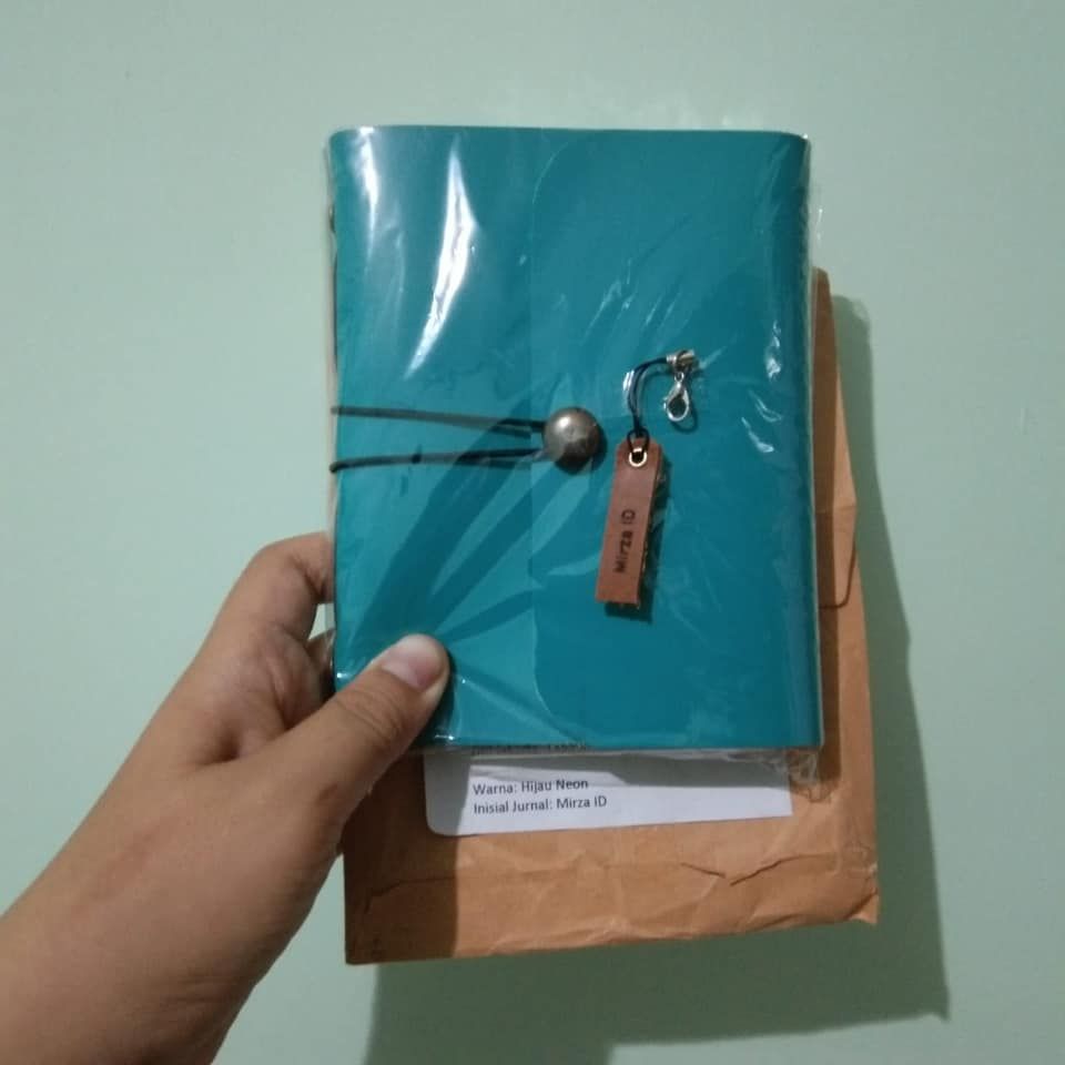 Jurnal Hibrkraft kustom warna Hijau Neon dengan tag nama Mirza ID, baru diterima dalam kemasan.