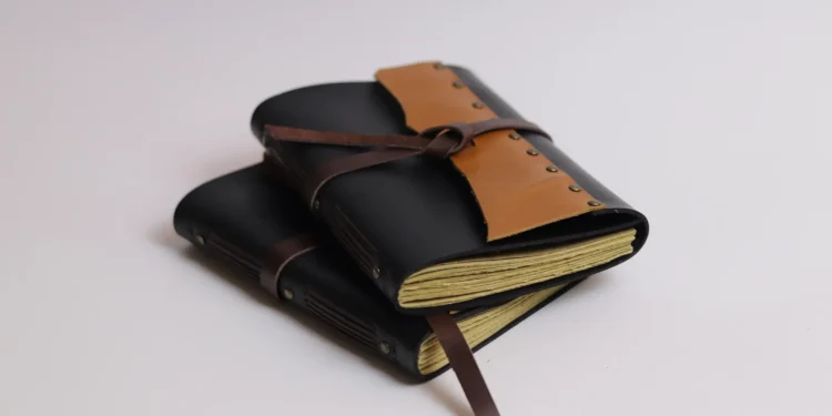 Two Black And Tan Leather Notebooks Stacked