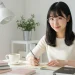 Young Woman Writing In Notebook At Desk
