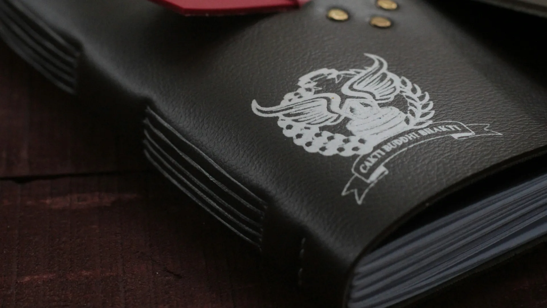 Buku catatan kulit hitam dengan logo kustom, menampilkan kualitas produk Hibrkraft