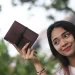 Woman Holding Brown Leather Journal Outside