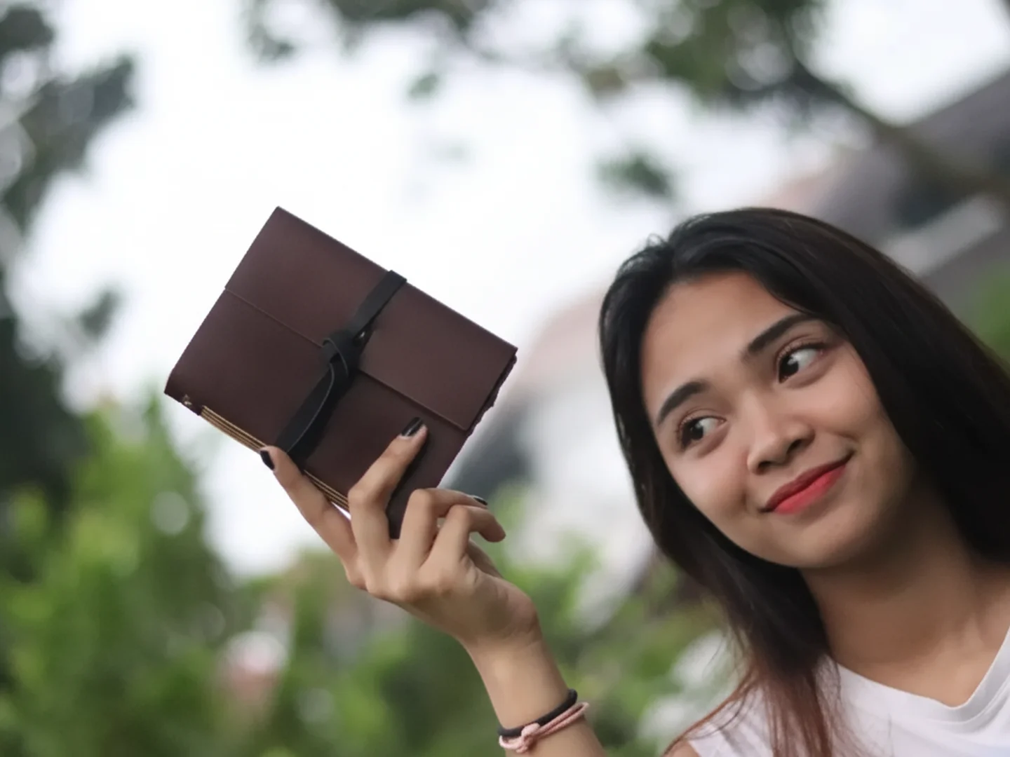 Woman Holding Brown Leather Journal Outside Woman Holding Brown Leather Journal Outside