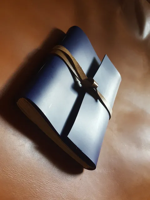 Jurnal kulit baru berwarna biru, siap untuk memulai perjalanan dan mengembangkan patinanya sendiri.